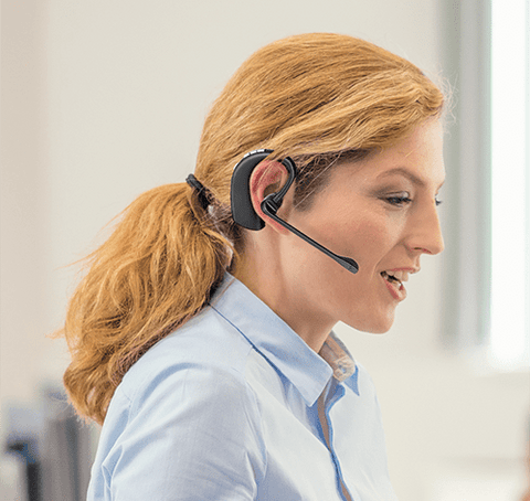 Woman  using an electronic hookswitch for remote answering with a Leitner headset