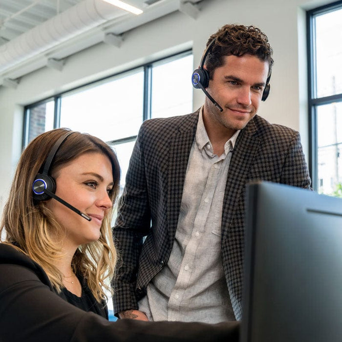 Office workings using LH570 wireless headset while training at computer